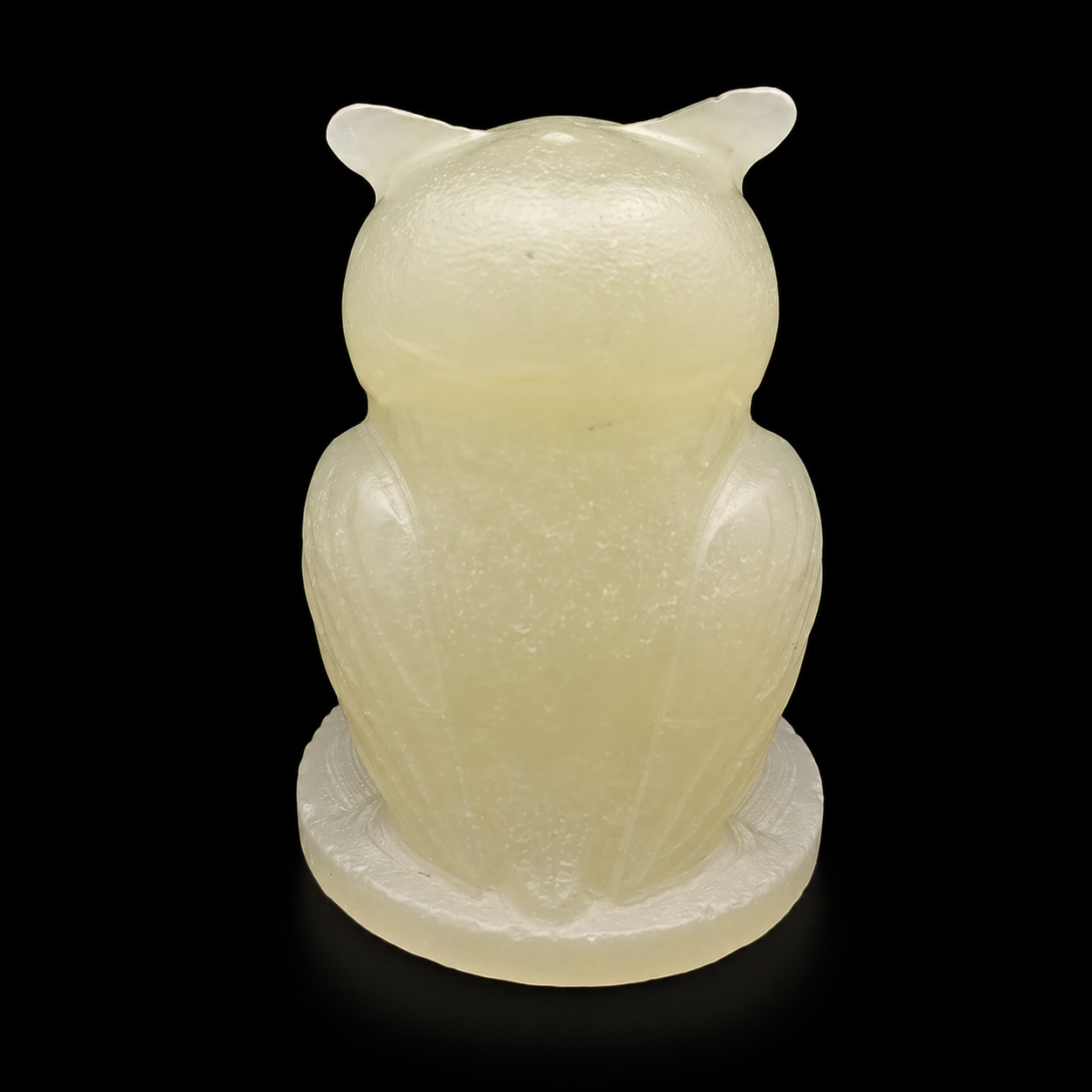 Back view of green onyx owl carving highlighting polished stone texture and shape