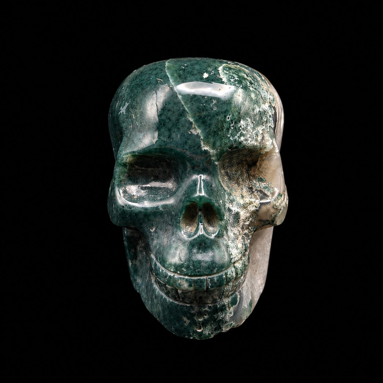 Moss agate skull front view with deep green natural inclusions and polished carved facial details