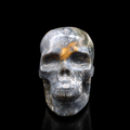 Front view of a polished blue moss agate skull carving with grey-blue tones, golden markings and natural moss-like inclusions