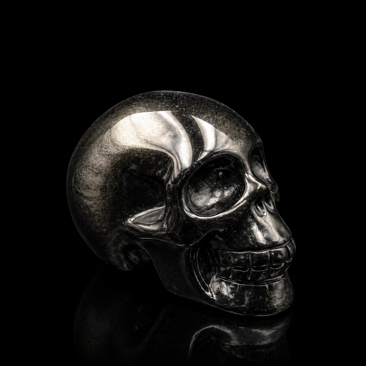Silver Sheen Obsidian skull right-facing angled side view, polished black obsidian carving with natural metallic silver sheen