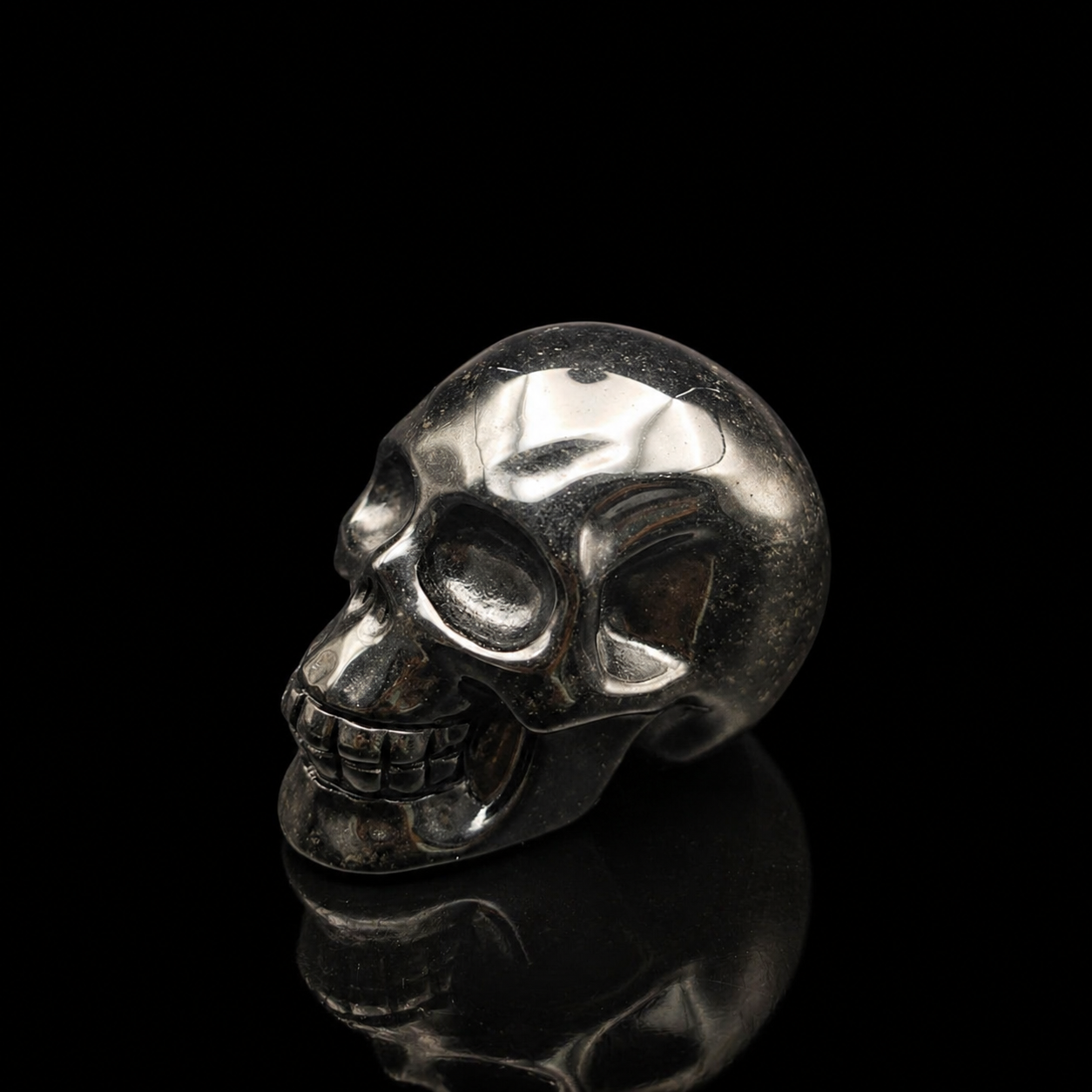 Silver Sheen Obsidian skull left-facing angled side view, 500g carved black obsidian skull with glossy silver reflections