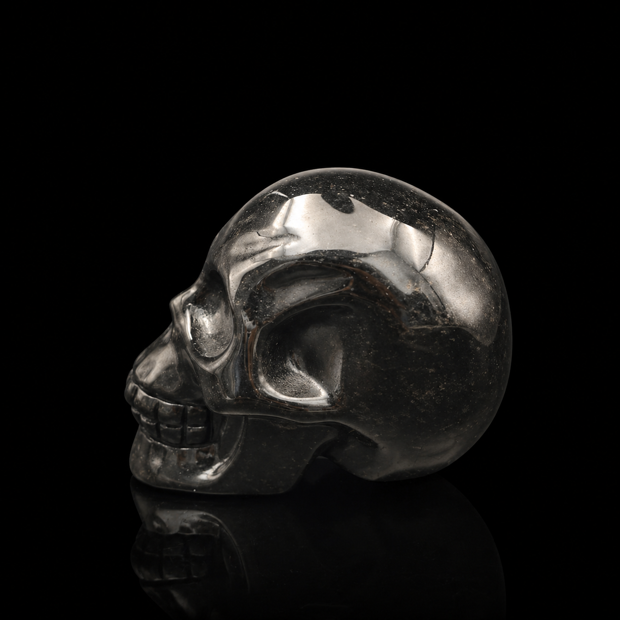 Silver Sheen Obsidian skull left-facing full side view, 500g polished black crystal carving with natural metallic silver sheen and detailed skull profile.