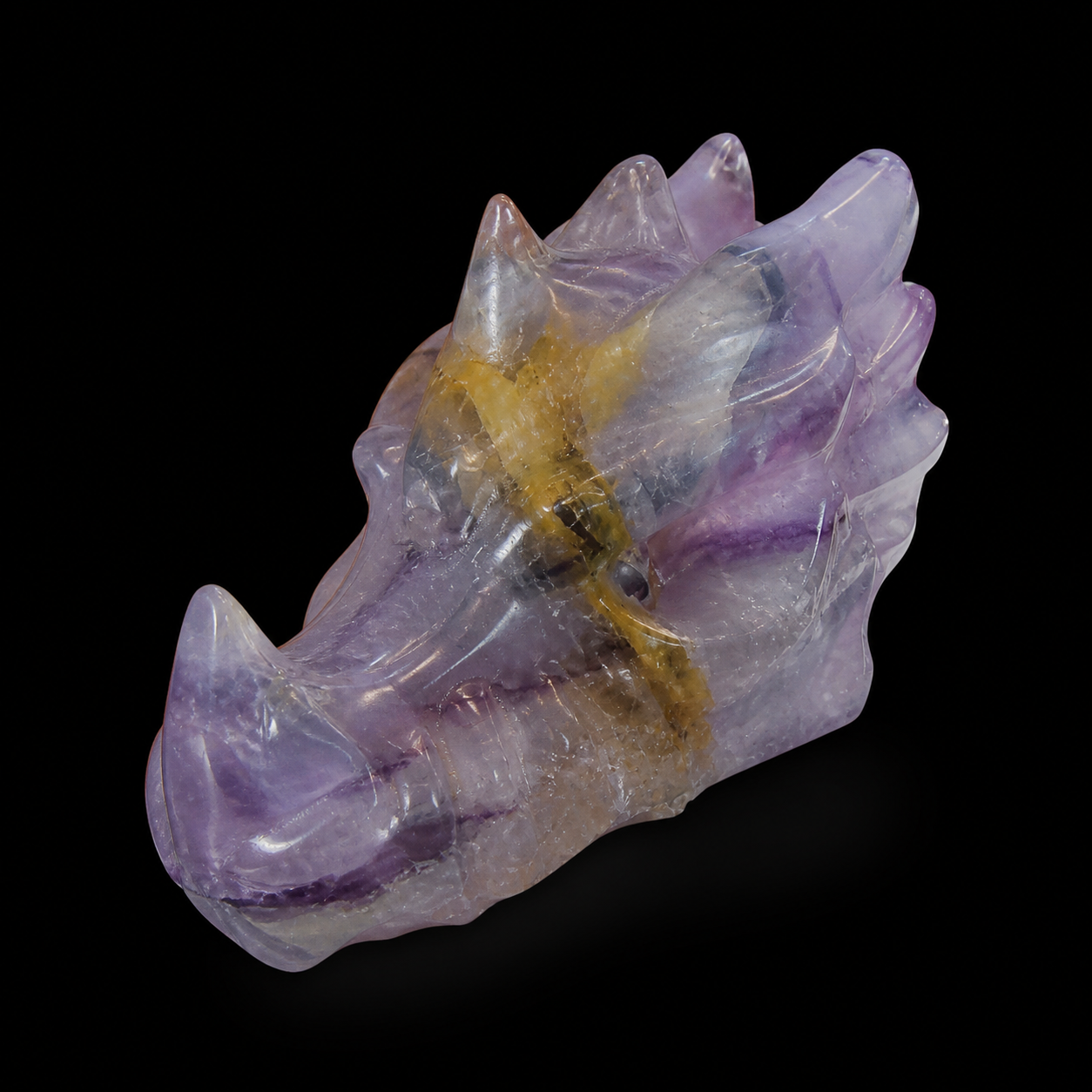 Fluorite dragon head angled front view with translucent lavender tones, purple banding and carved horn details