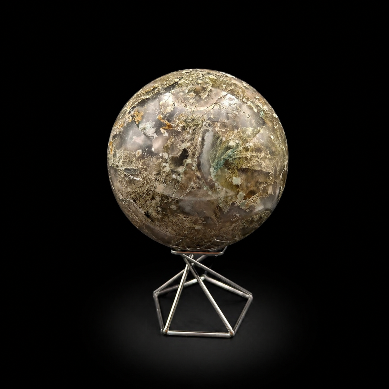 Slightly rotated front view of a polished moss agate sphere 840g showing green, beige and translucent inclusions
