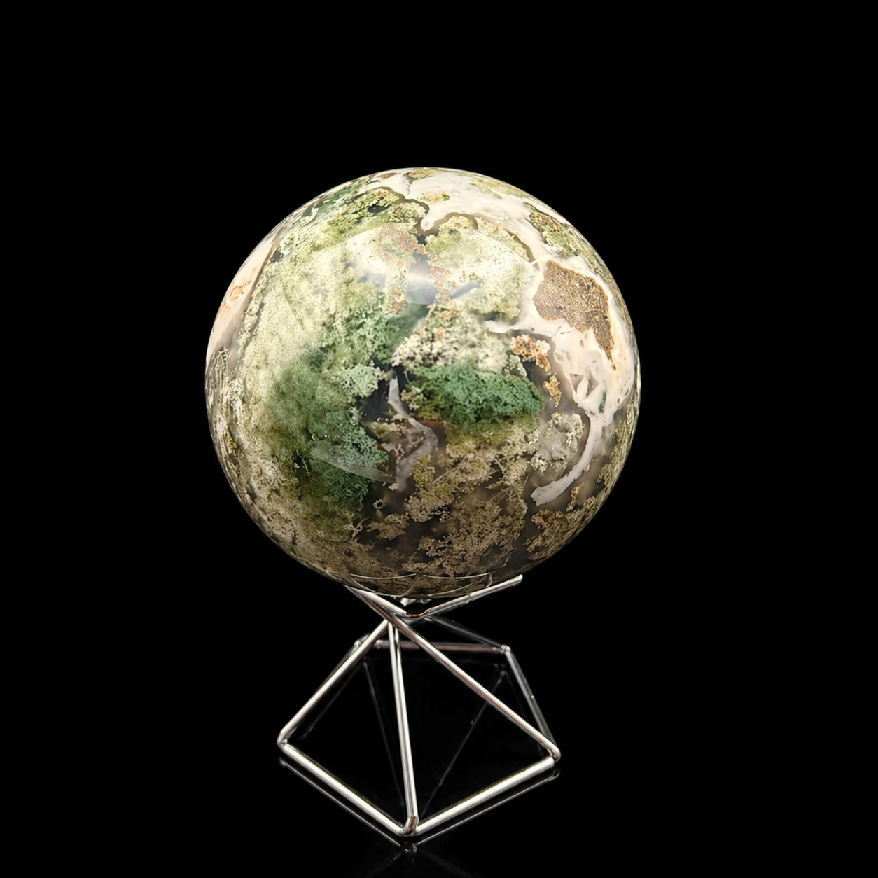 Slightly rotated front view of a polished moss agate sphere 500g showing green moss-like inclusions, translucent areas and creamy white natural patterns