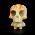Green banded onyx skull figure with pale green translucent stone and orange natural veining, front view