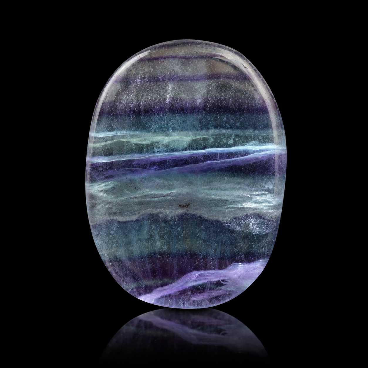 Polished banded fluorite flat palm stone, close-up detail view showing purple, blue-green and translucent bands with glossy finish