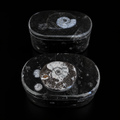 Top view of oval fossil jasper jewellery boxes showing polished ammonite fossil patterns on dark stone