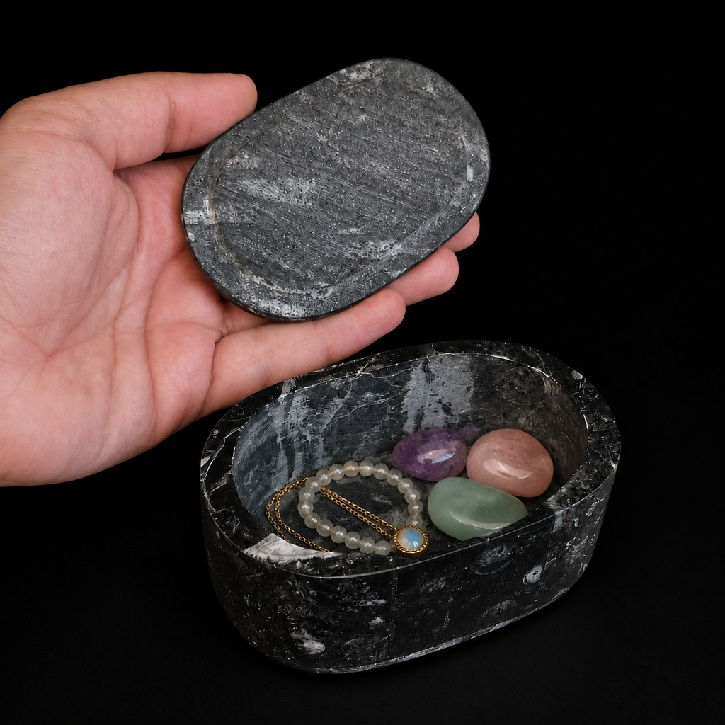 Open oval fossil jasper jewellery box with necklace, bracelet and polished mineral tumbles inside