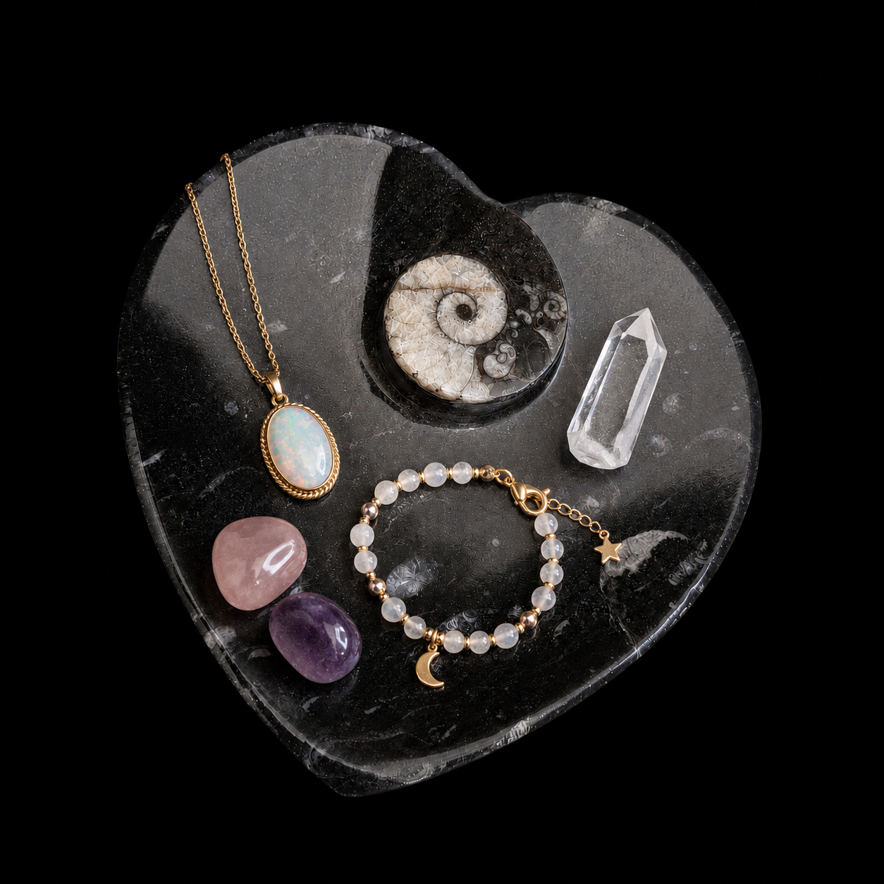 Heart-shaped fossil jasper dish displaying a pendant necklace, beaded bracelet, clear quartz point and polished mineral stones