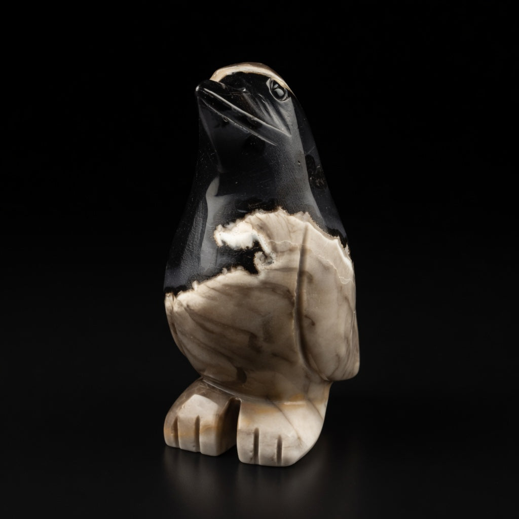 Front three-quarter view of natural moss agate penguin carving displaying the face, beak and body with dramatic black and beige patterns, unique 526g piece