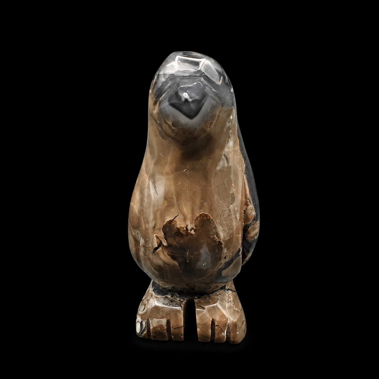 Front view of a UV reactive volcanic agate penguin carving 465g with smoky grey and brown natural banding