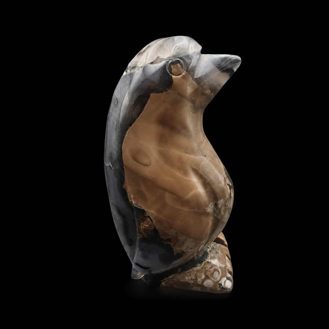 Right side view of a UV reactive volcanic agate penguin carving 465g with warm brown and dark grey agate banding