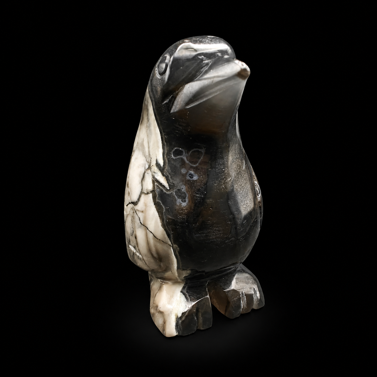 UV reactive volcanic agate penguin carving 533g front angled view, polished black and cream marbled mineral figurine
