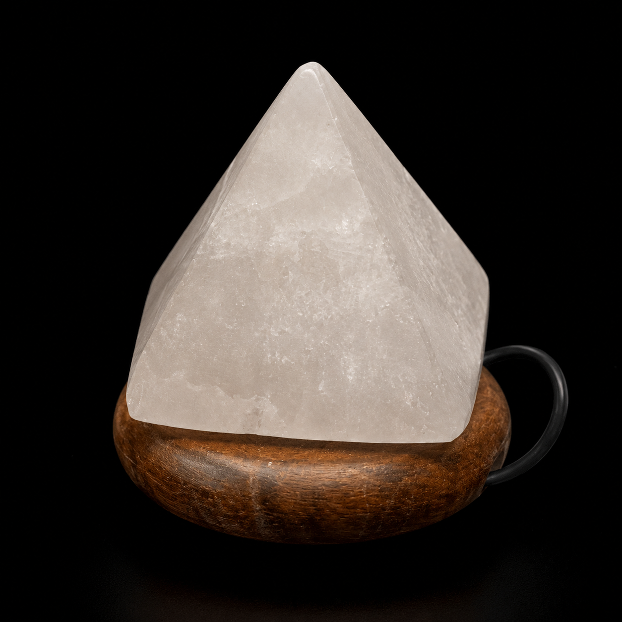 Angled front view of a white quartz 7 chakras LED lamp on a rounded wooden base, showing its translucent mineral texture and power cable.