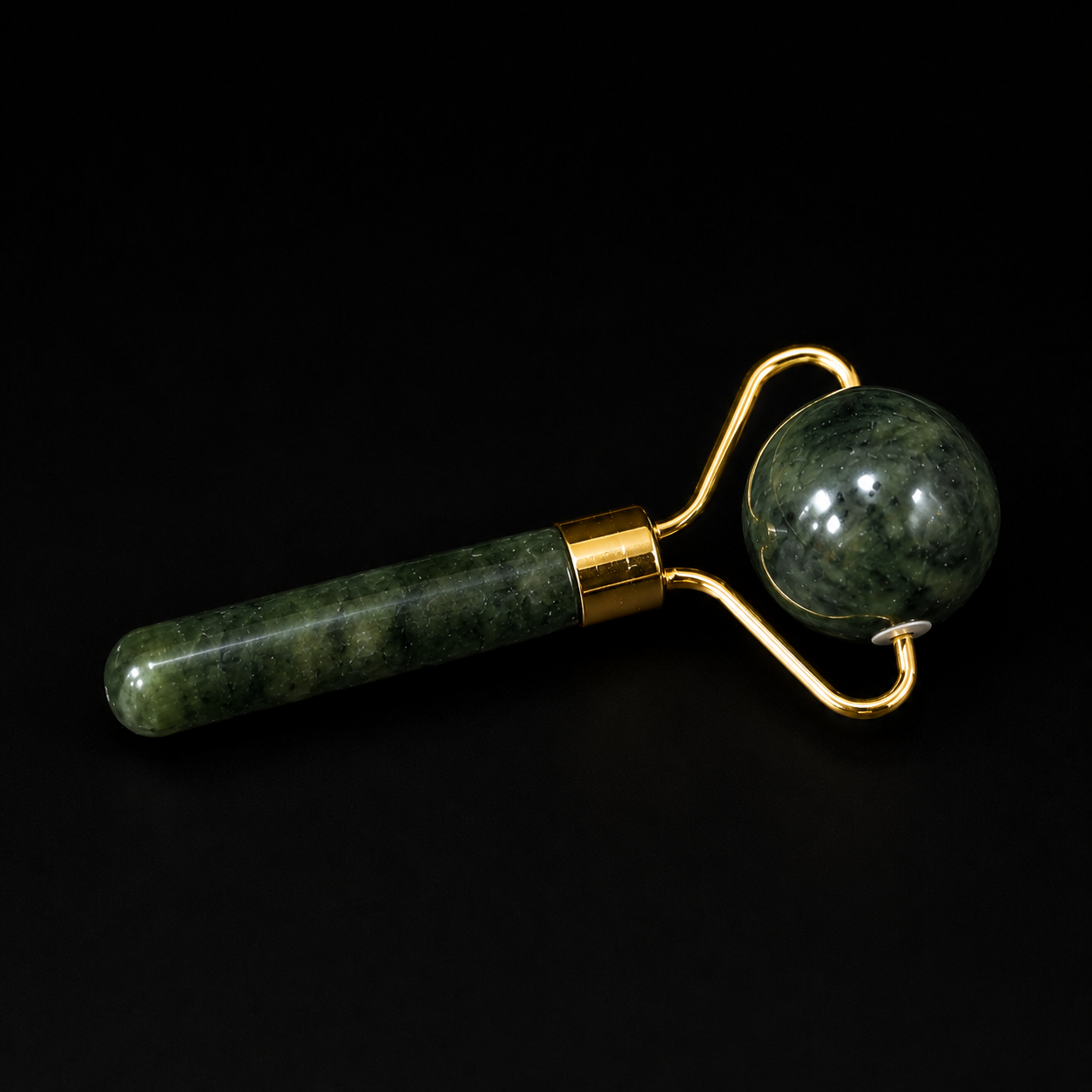 Jade facial massage roller with spherical roller head and gold-tone fittings on a black background.
